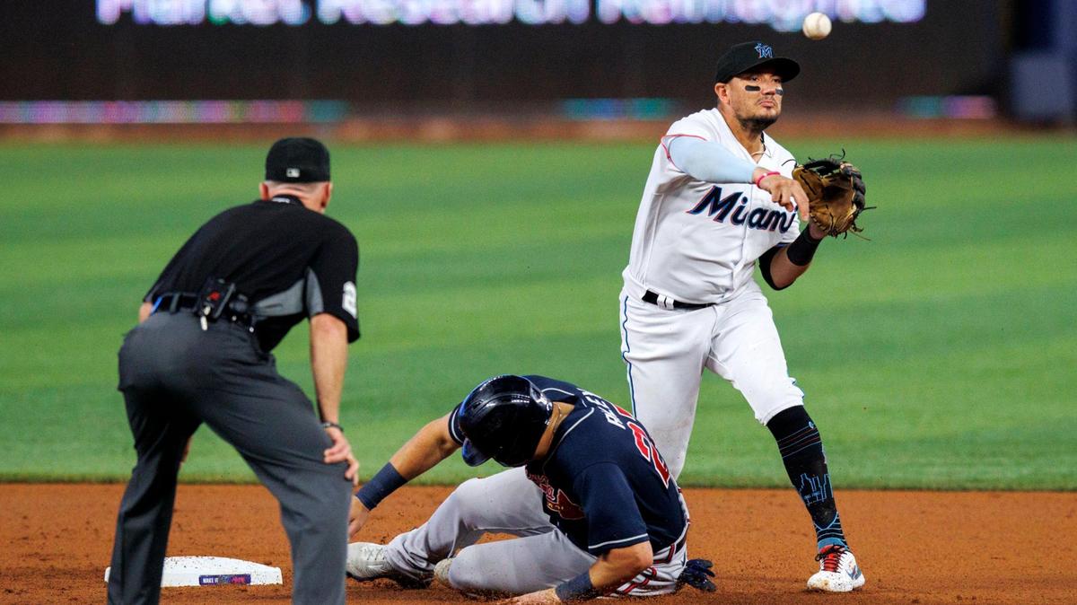 Atlanta Braves third baseman Austin Riley (27) slides into second base as Miami Marlins shortstop Miguel Rojas (11) throws to complete the double play during the first inning of a baseball game at LoanDepot Park on Sunday, August 14, 2022 in Miami, Florida.