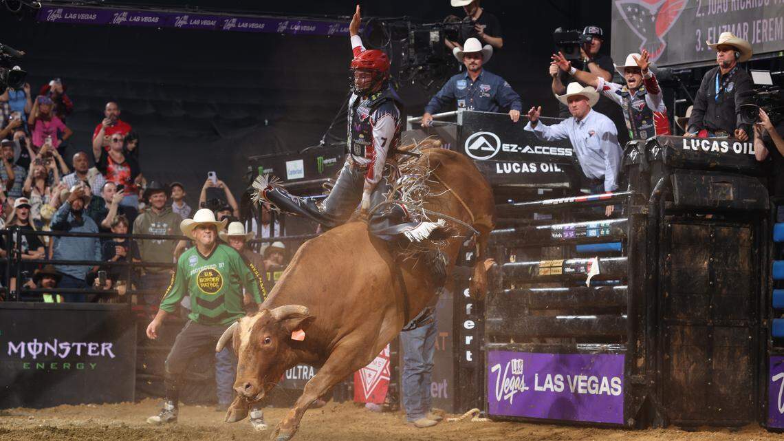 Florida Freedom’s John Crimber rides bull The Player at Amerant Bank Arena in Sunrise. His father and coach John Crimber, wearing a white cowboy hat and dark blue shirt, watches in the background.
