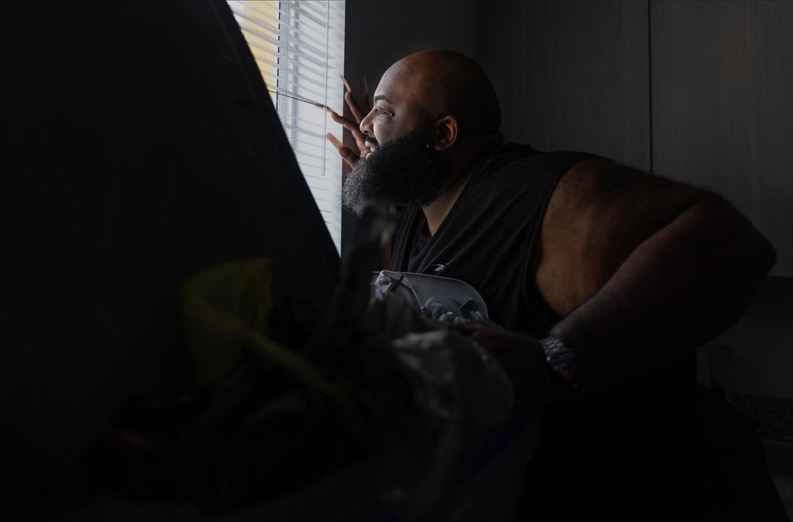 Christopher Saunders, 43, looks out his window and admires the view from his apartment at Wenski Groves. Saunders moved to the affordable housing complex after struggling to afford his condo in North Miami Beach.