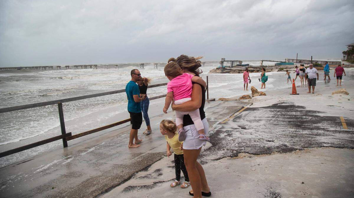 People gather on Fort Myers Beach, Fla. to watch the Gulf of Mexico as Hurricane Helene passes by on Thursday, Sept. 26, 2024.