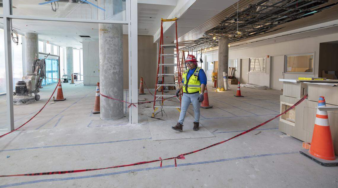 A construction worker makes her way through Jackson Memorial Hospital's new emergency department lobby on Thursday, March 5, 2026, in Miami, Fla. The new facility doubles the size of the current emergency room and is expected to reduce patient wait times.