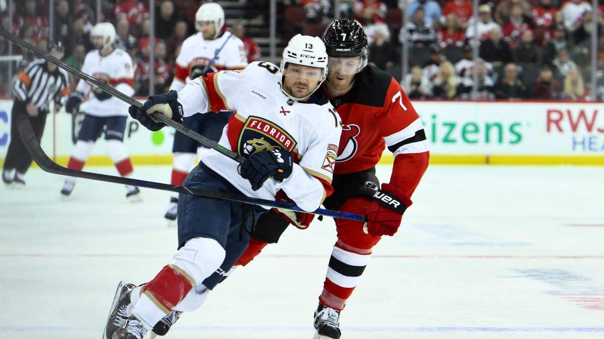 Oct 16, 2023; Newark, New Jersey, USA; Florida Panthers center Sam Reinhart (13) skates with the puck against New Jersey Devils defenseman Dougie Hamilton (7) during the third period at Prudential Center. Mandatory Credit: John Jones-USA TODAY Sports