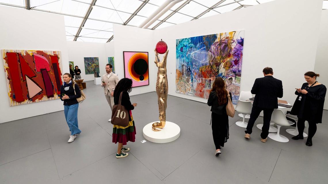 Guests look at a gallery from the Makasiini Contemporary featuring pieces from artists like Jiri Geller and Ola Kolehmainen inside the Untitled Art Fair tent off Ocean Drive.