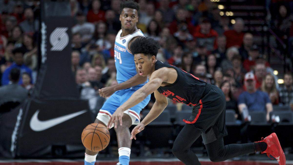 Portland Trail Blazers guard Anfernee Simons, right, reaches for a loose ball in front of Sacramento Kings guard Buddy Hield during the first half of an NBA basketball game in Portland, Ore., Wednesday, April 10, 2019.