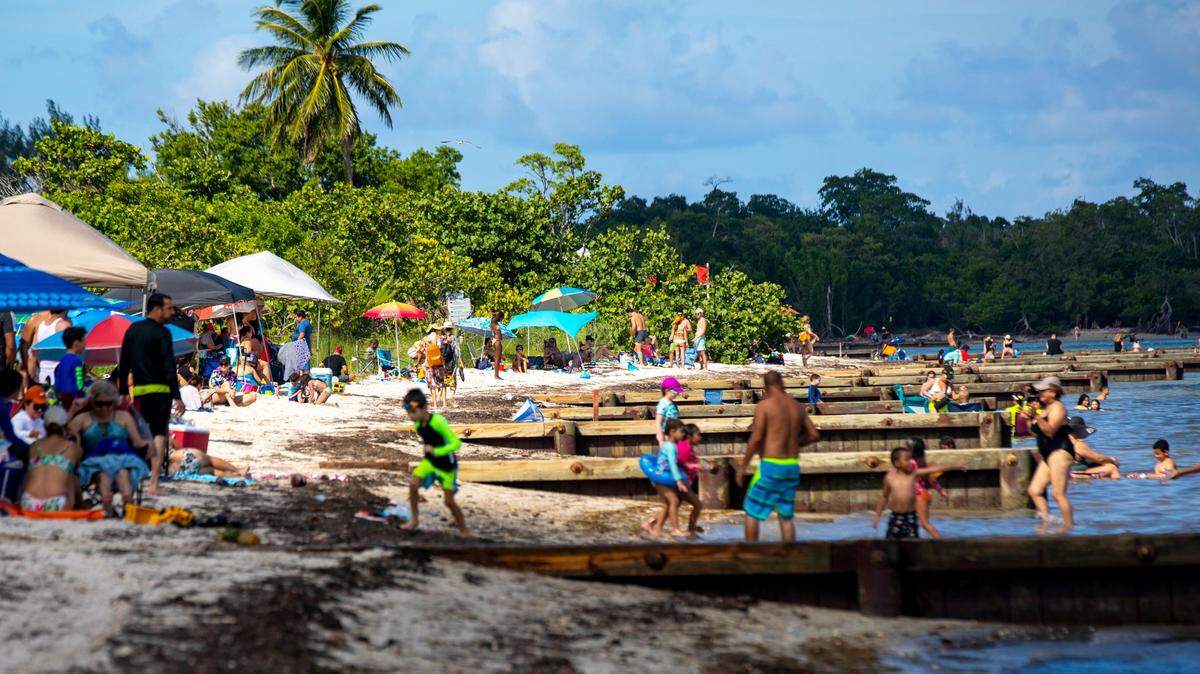 Personas toman el sol y nadan durante la celebración reprogramada del 75 aniversario del Parque Histórico de Virginia Key Beach el sábado 8 de agosto de 2020.