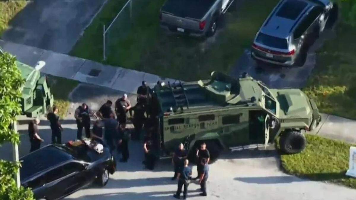 Miami-Dade Sheriff’s Office Special Response Team deputies stand outside a Palmetto Estates home Tuesday, Dec. 2, 2025, where deputies shot and killed a man while serving a search warrant amid a child pornography investigation.