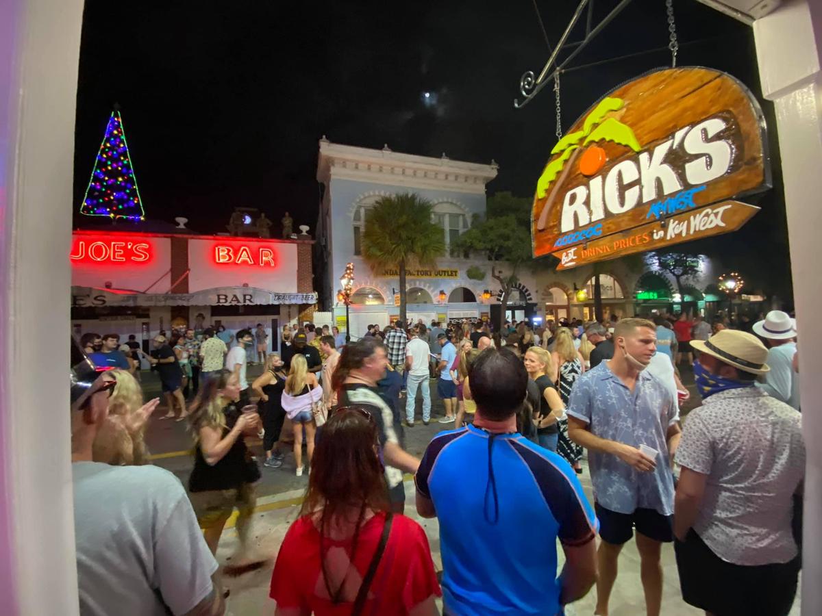 People linger in the 200 block of Duval Street before police enforced the city’s 10 p.m. curfew on Dec. 31, 2020.