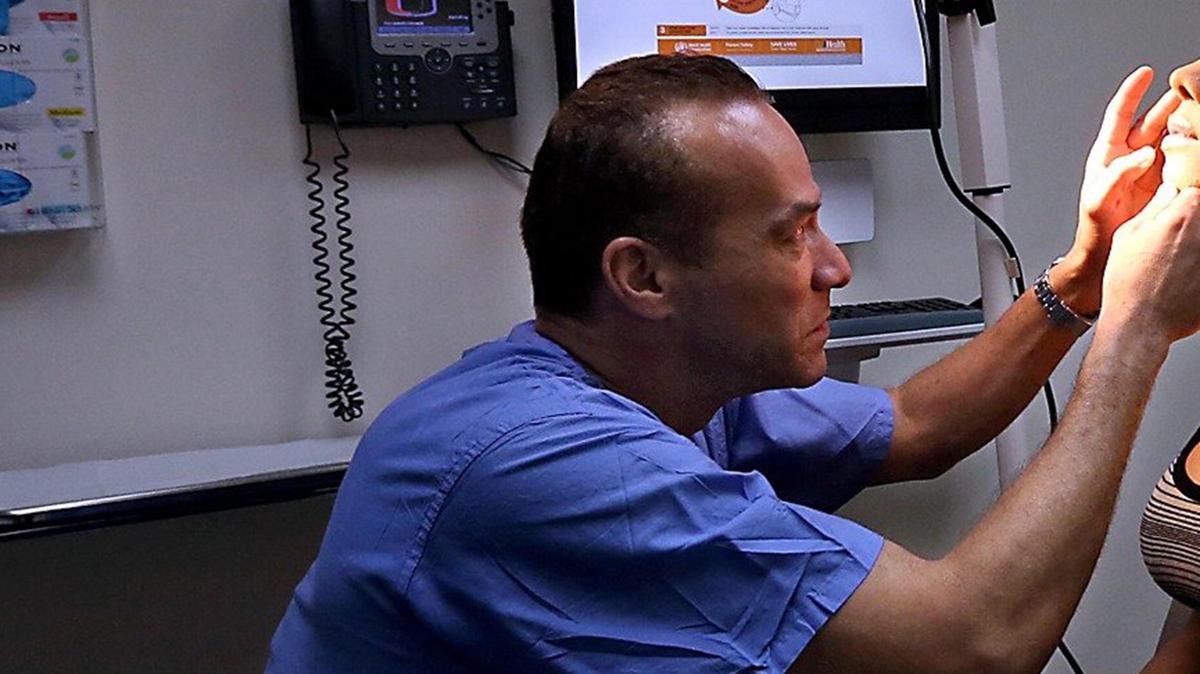 In this February 2017 photo, Dr. Christopher Salgado (left) examines a patient. Salgado, section chief for the University of Miami Health System’s LGBTQ Center for Wellness, Gender and Sexual Health, said he resigned after transgender advocates complained about graphic photos with crude comments on his Instagram account.