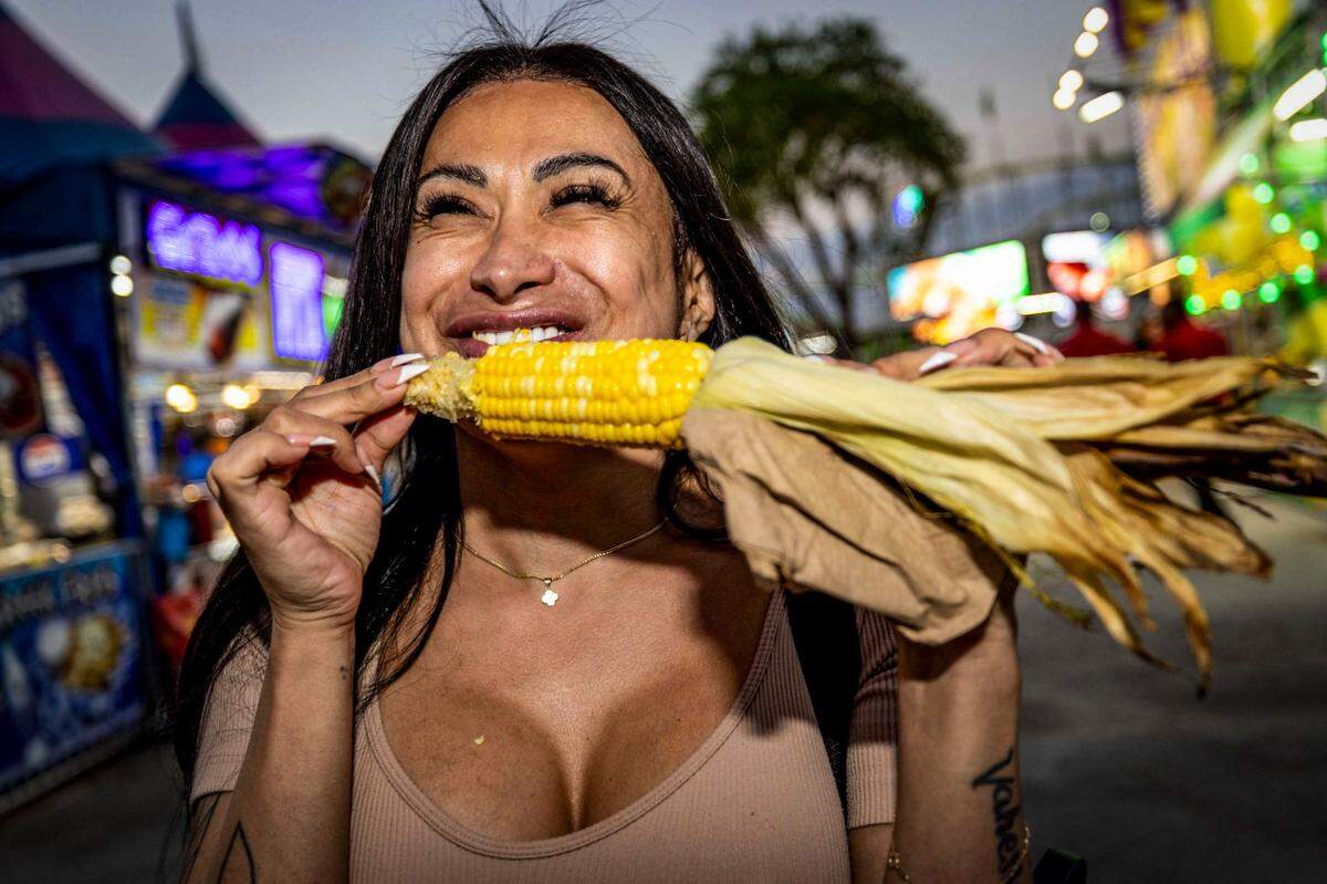Veronica Reyes, takes a bite out of an ear of corn at the Miami-Dade County Fair and Exposition