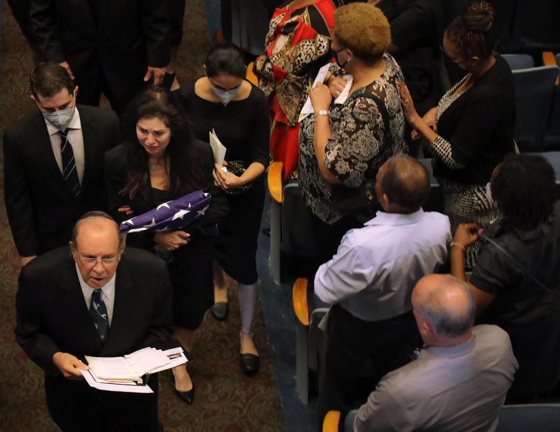 Harvey Ruvin’s widow, Risa Ruvin, center, clutches the American flag that draped her husband’s casket during its procession closely followed by family members. On Thursday, Jan. 5, 2023, a celebration of life service was held for the longtime Miami-Dade County Clerk of the Courts, Harvey Ruvin, at the Miami-Dade County Auditorium in Miami, Florida.