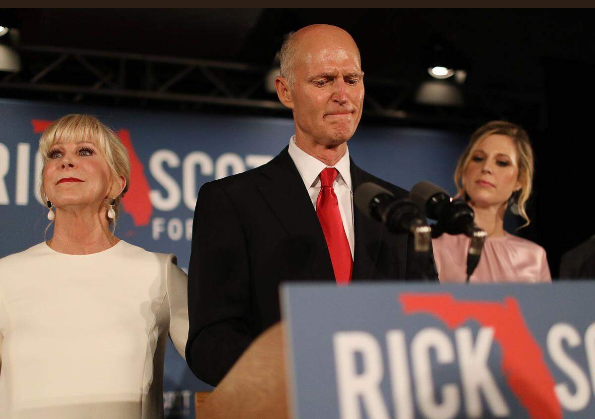 Florida Gov. Rick Scott pauses as he becomes emotional while speaking as he stands with his wife, Ann Scott, (L) and daughter Alison Guimard (R) during his election night party at the LaPlaya Beach & Golf Resort  on Nov.  6, 2018, in Naples, Florida. The race between Scott and Democratic Sen. Bill Nelson is being recounted by hand in the state’s 67 counties, after a machine recount determined the margin between the two was less than 0.25 percent, the threshold for a hand recount. The Florida Secretary of State ordered the recount on Thursday, Nov. 15.