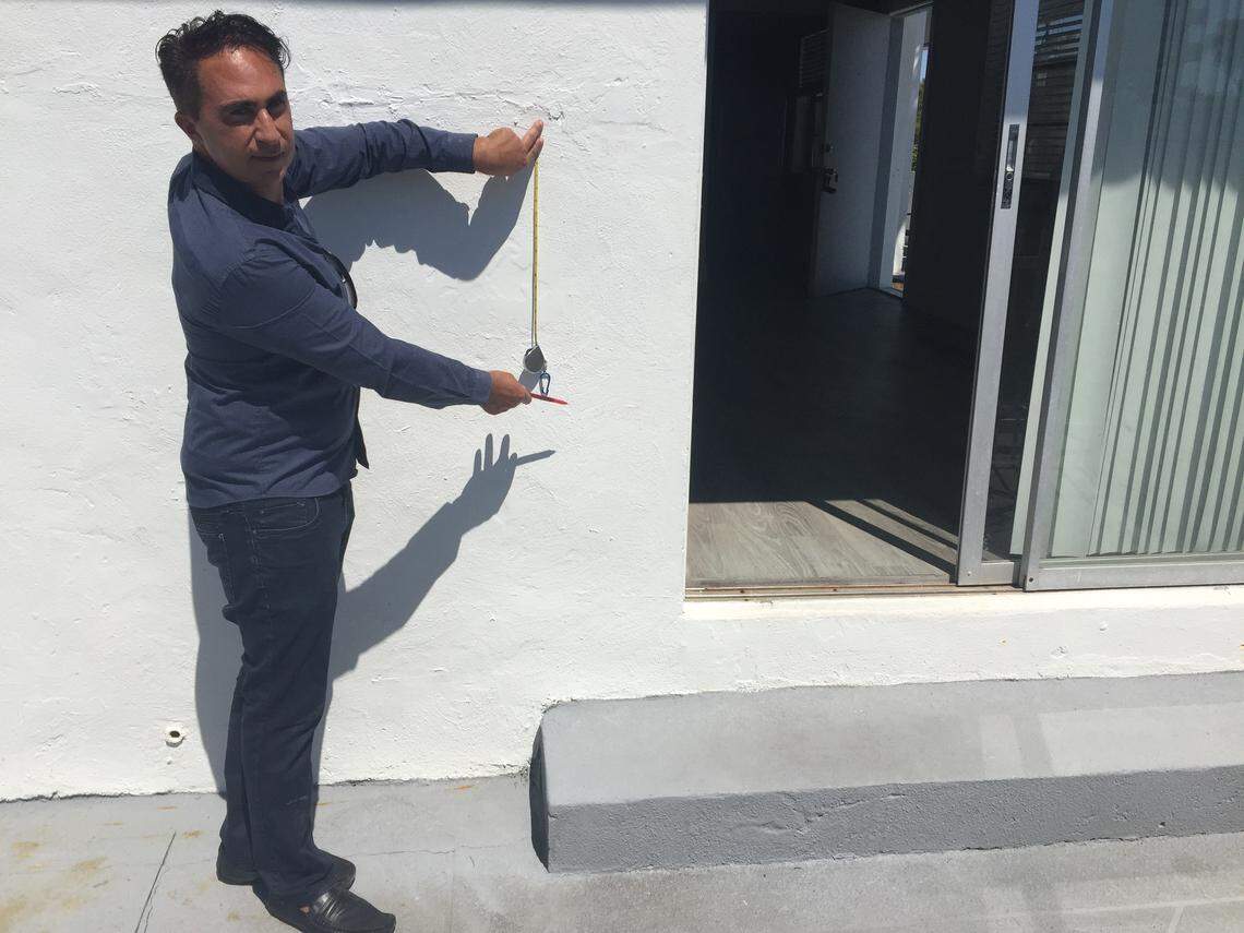 Pierre Elmaleh, a property owner in the Tatum Waterway neighborhood, demonstrates how high he’d need to raise one of his apartment buildings to keep it safe from floods.