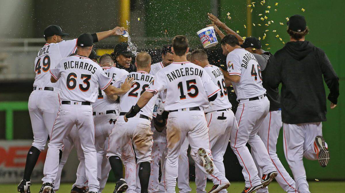 Miami Marlins players celebrate after a 5-4 win over the Milwaukee Brewers after Starlin Castro hits a walk off single during the twelfth inning of a Major League Baseball game at Marlins Park on Wednesday, July 11, 2018. 