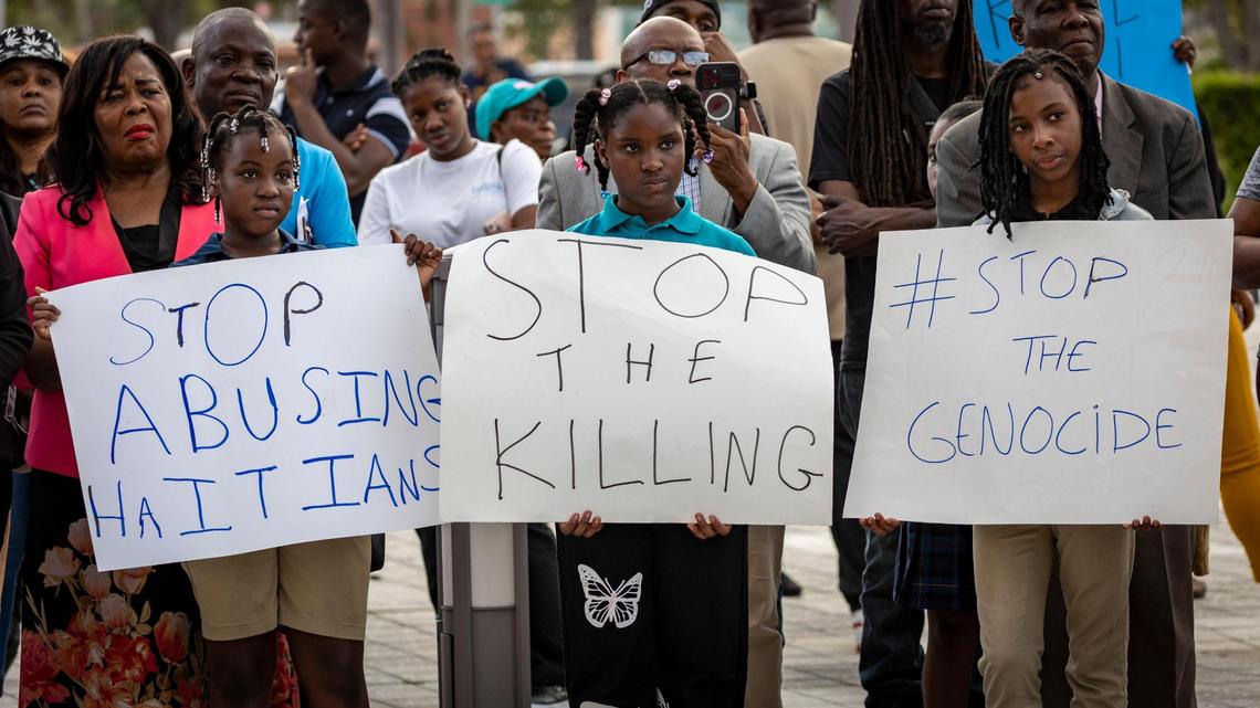 Children carry signs during a press conference in North Miami on March 5 to draw attention to the problems in Haiti.