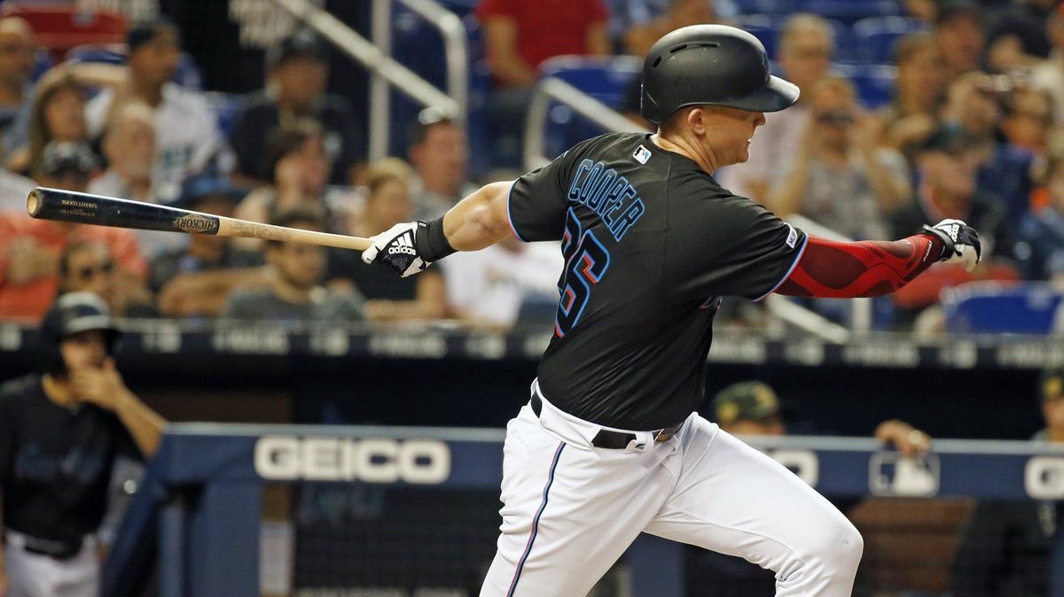 Miami Marlins left fielder Garrett Cooper (26) singles and brings in Miami Marlins shortstop Miguel Rojas (19) and third baseman Jon Berti (55) to score in the third inning as the Miami Marlins open a three-game series with the New York Mets at Marlins Park on Friday, May 17, 2019.