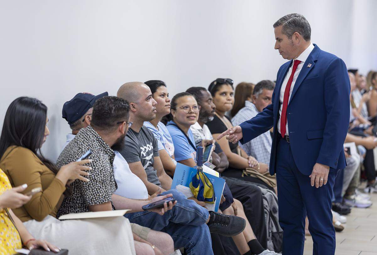 Miami-Dade Tax Collector Dariel Fernandez talks with Yasmani Solis, 37, from Little Havana, as he waits in line at the Florida Highway Safety and Motor Vehicles Driver License and Motor Vehicle Service Center on April 16, 2025, in Miami, Fla.
