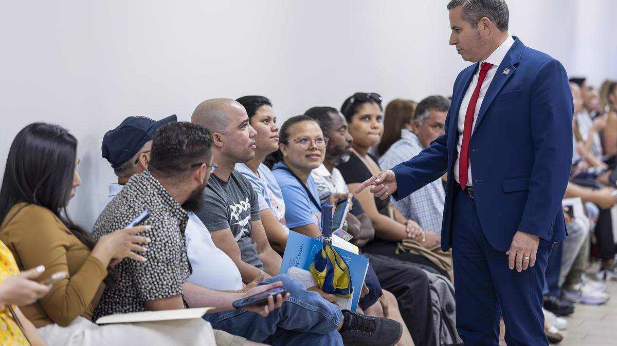 Miami-Dade Tax Collector Dariel Fernandez talks with Yasmani Solis, 37, from Little Havana, as he waits in line at the Florida Highway Safety and Motor Vehicles Driver License and Motor Vehicle Service Center on April 16, 2025, in Miami, Fla.