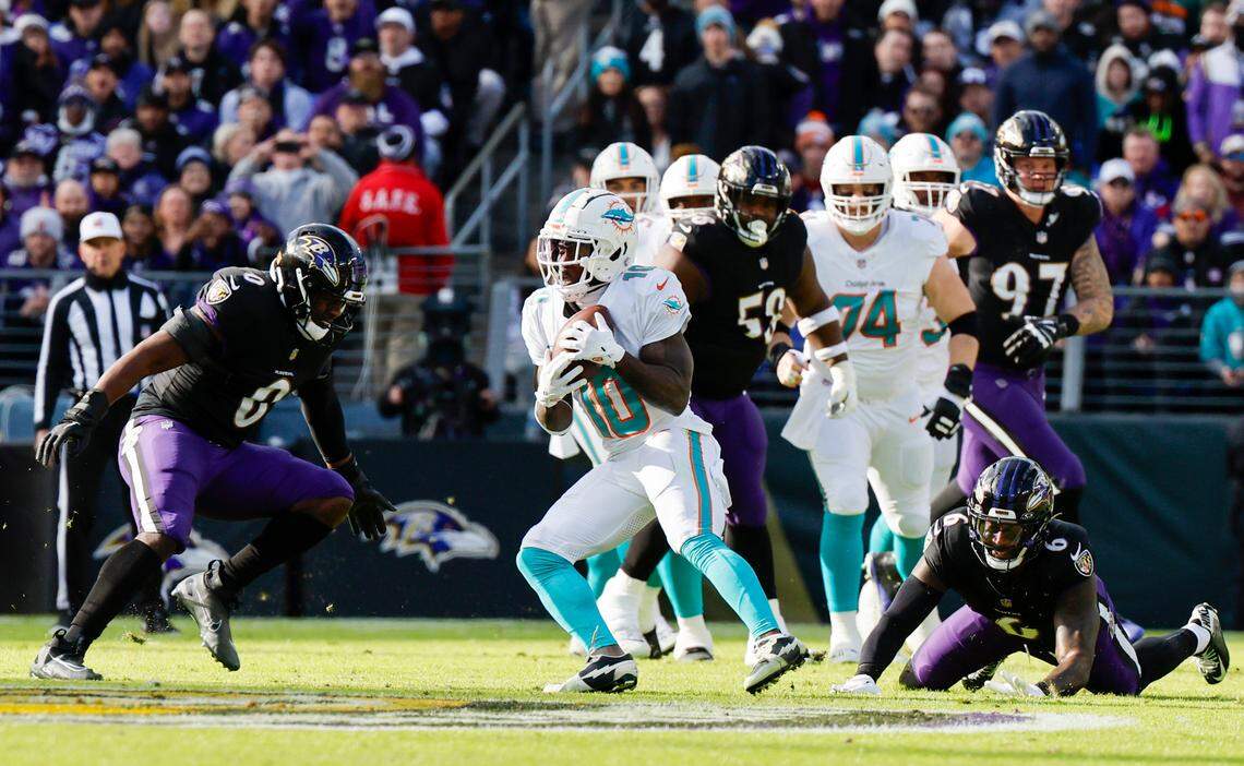 Miami Dolphins wide receiver Tyreek Hill (10) catches a pass as Baltimore Ravens linebacker Roquan Smith (0) and Ravens linebacker Patrick Queen (6) defend during first half of an NFL football game against the Baltimore Ravens at M&T Bank Stadium in Baltimore, Maryland on Sunday, December 31, 2023.