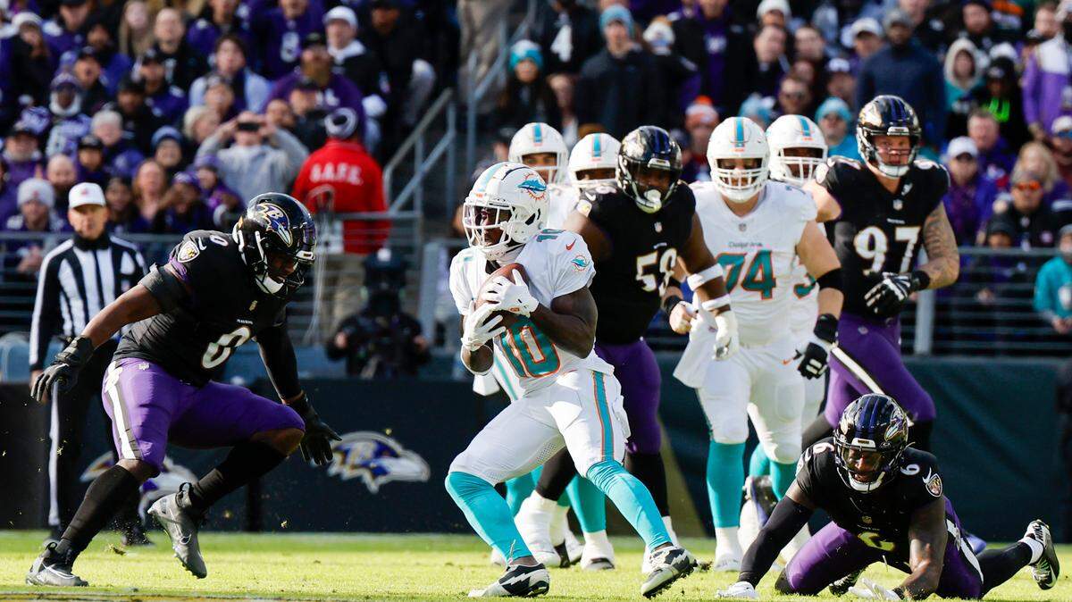 Miami Dolphins wide receiver Tyreek Hill (10) catches a pass as Baltimore Ravens linebacker Roquan Smith (0) and Ravens linebacker Patrick Queen (6) defend during first half of an NFL football game against the Baltimore Ravens at M&T Bank Stadium in Baltimore, Maryland on Sunday, December 31, 2023. 