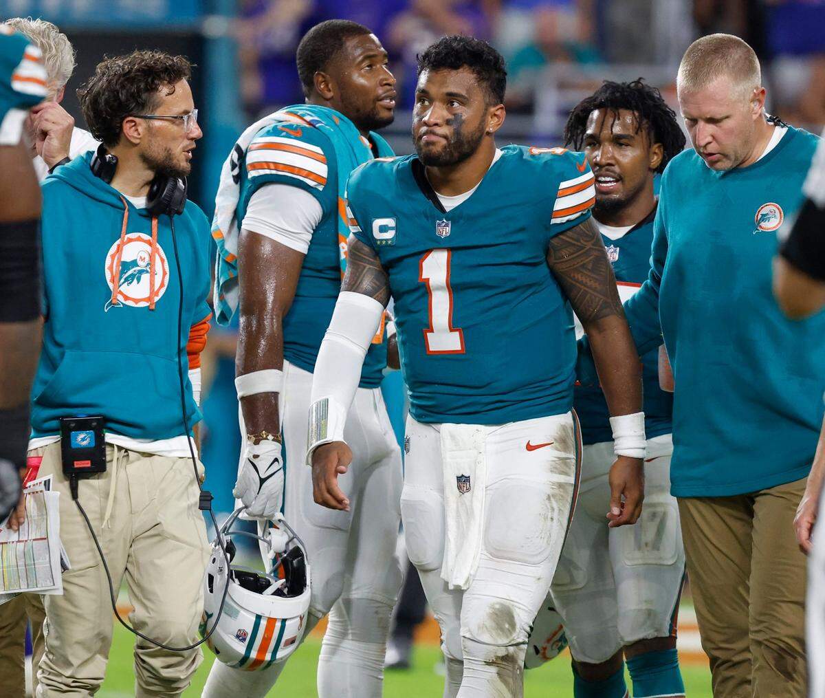 Miami Dolphins quarterback Tua Tagovailoa (1) is assisted off the field in the third quarter after an injury during the game against the Buffalo Bills in an NFL game at Hard Rock Stadium on Thursday, September 12, 2024.