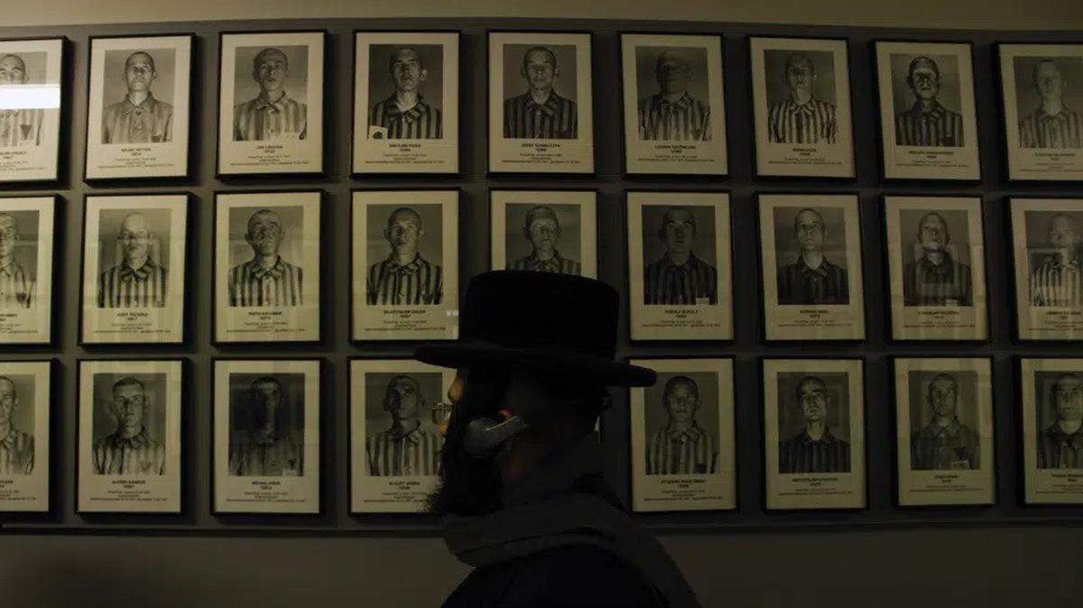An orthodox Jewish man walks past portraits of victims at the former Nazi concentration and extermination camp Auschwitz-Birkenau in Oswiecim, Poland.