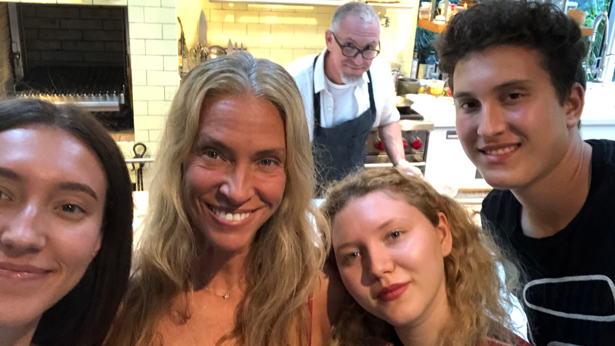 The Schwartz family -- Ella; mom Tamara; Lua​, who is a vegetarian;​ Harry; and chef Michael cooking in the background -- in the​ ​kitchen​ of their Miami Beach home​.