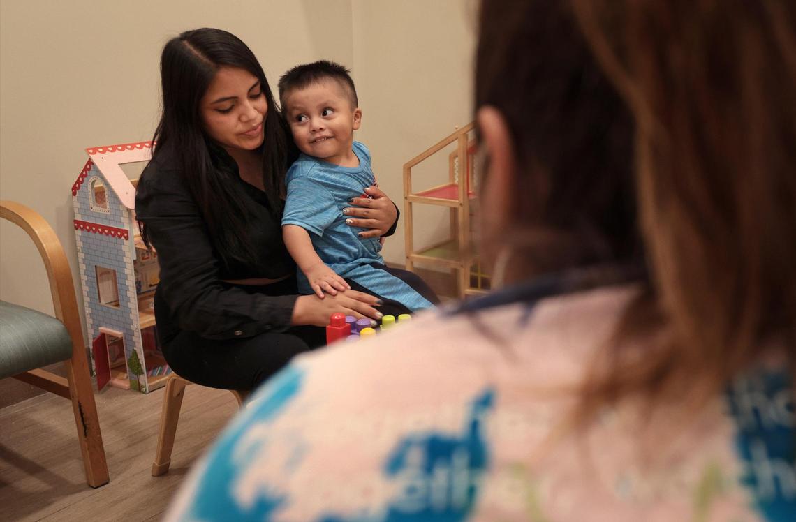Darwin Lopez, 2, center, and his mother, Teresa Lopez, 19, play together during parent-child interaction therapy at Lotus Village.