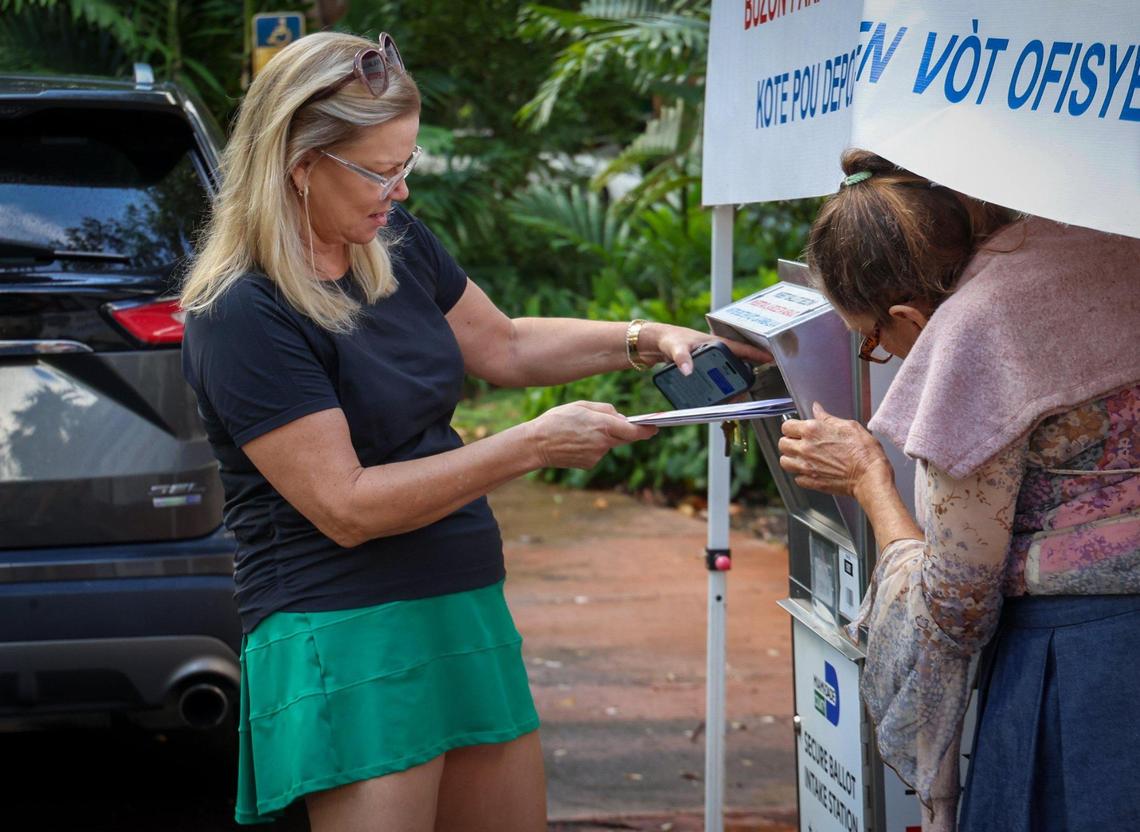A voter looks to place her ballot in the intake station at the Coral Gables Library to cast their vote during early voting on Monday, October 21, 2024, in Coral Gables, Florida.