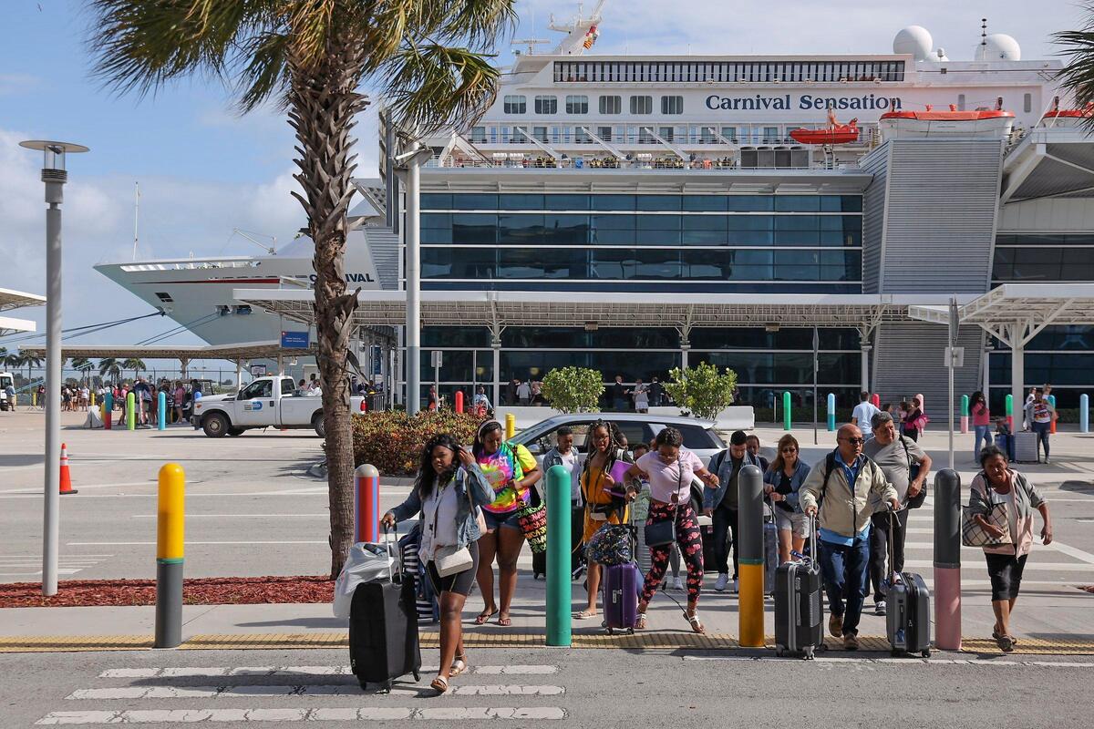 Los pasajeros de cruceros desembarcan del Carnival Sensation el lunes 9 de marzo de 2020, después de un fin de semana de transmisión del coronavirus relacionado con el crucero.