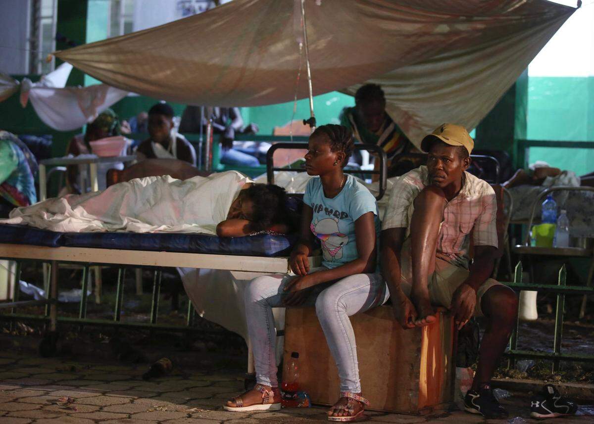 Las personas desplazadas de sus casas destruidas por un terremoto pasan la noche al aire libre en el jardín del hospital en Les Cayes, Haití, el sábado 14 de agosto de 2021.