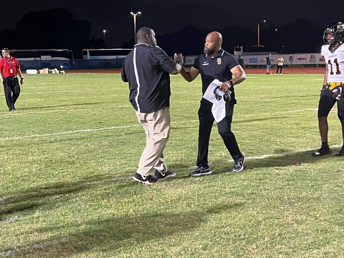 Miramar coach AJ Scott (left) and Highland Springs coach Loren Johnson (right) meet at midfield after the Patriots lost 20-14 in a Broward Showcase matchup at Miramar High on Friday.