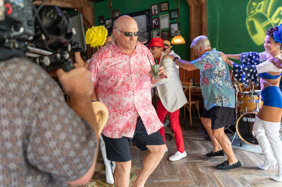 Terry Bradshaw with a mojito leads the conga line at Ball & Chain with Jimmy Johnson near the back.