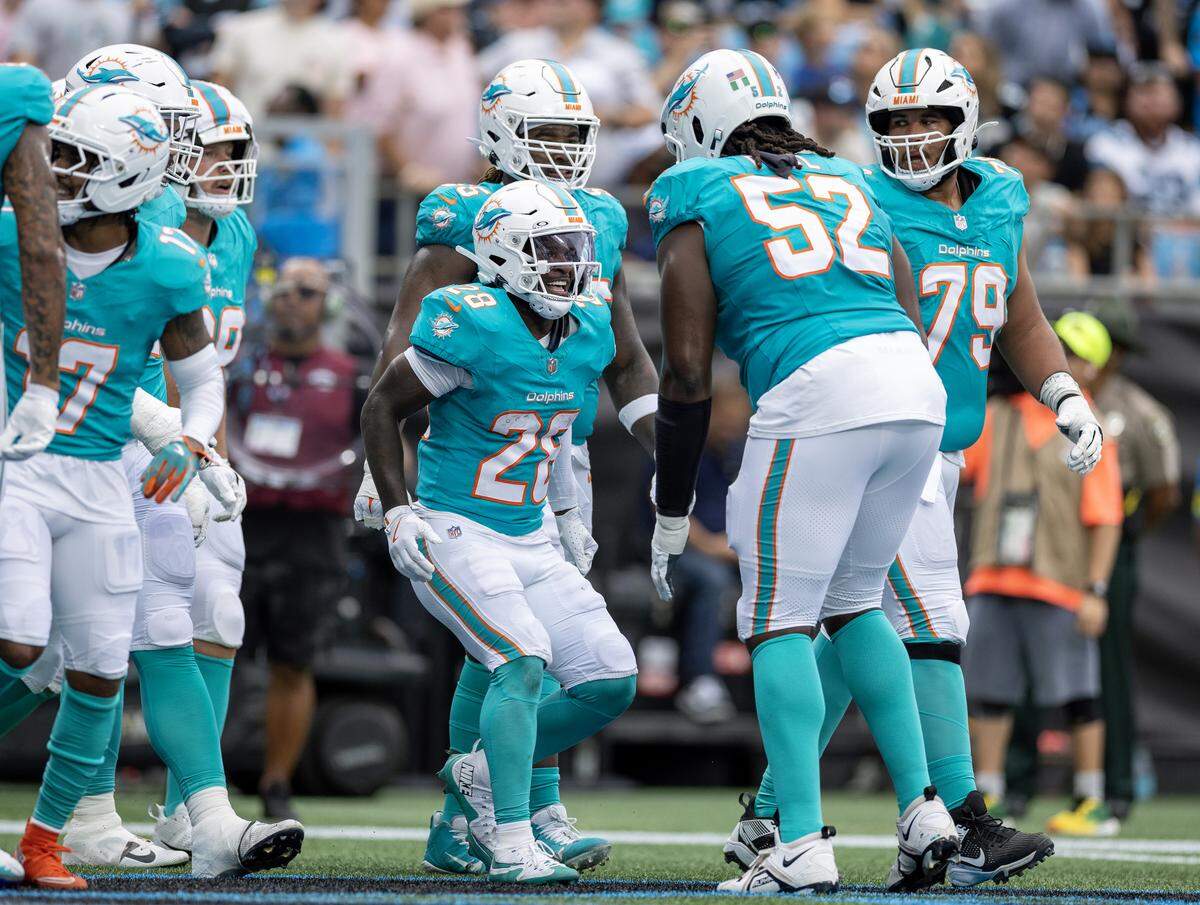 Miami Dolphins running back De’Von Achane (28) celebrates with teammates after scoring a touchdown during the first half of an NFL football game against the Carolina Panthers, Sunday, Oct. 5, 2025, in Charlotte, N.C.