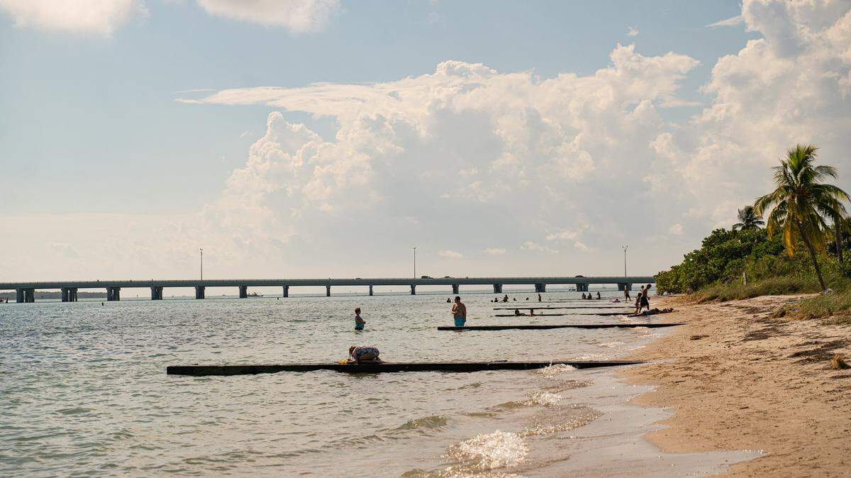 People are seen in the water and on the beach at Historic Virginia Key Beach Park on Key Biscayne, Florida on Saturday, November 12, 2022.
