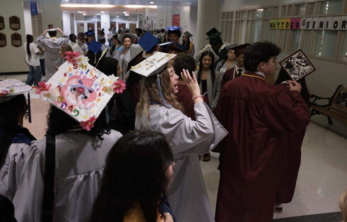 Ryan App, center, shouts to her friend from a different high school after high school graduates from all over Broward walk through the halls of their elementary school, Panther Run Elementary, on Monday, June 1, 2026, in Pembroke Pines, Fla. The school invited graduating alumni, from as far as Illinois, to come and walk through the school before it closes. 