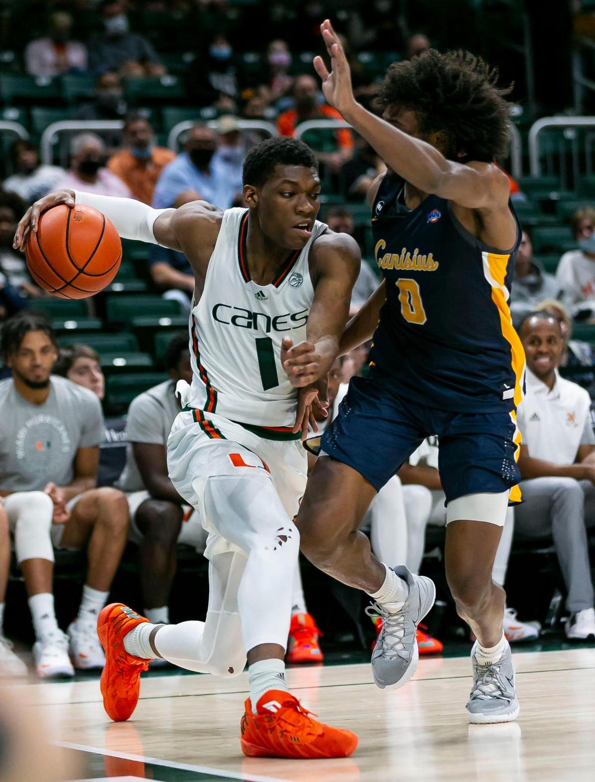 Miami Hurricanes forward Anthony Walker (1) looks to get past Canisius Golden Griffins guard Akrum Ahemed (0) during the second half of an NCAA men’s basketball game at the Watsco Center in Coral Gables, Florida on Tuesday, November 9, 2021.