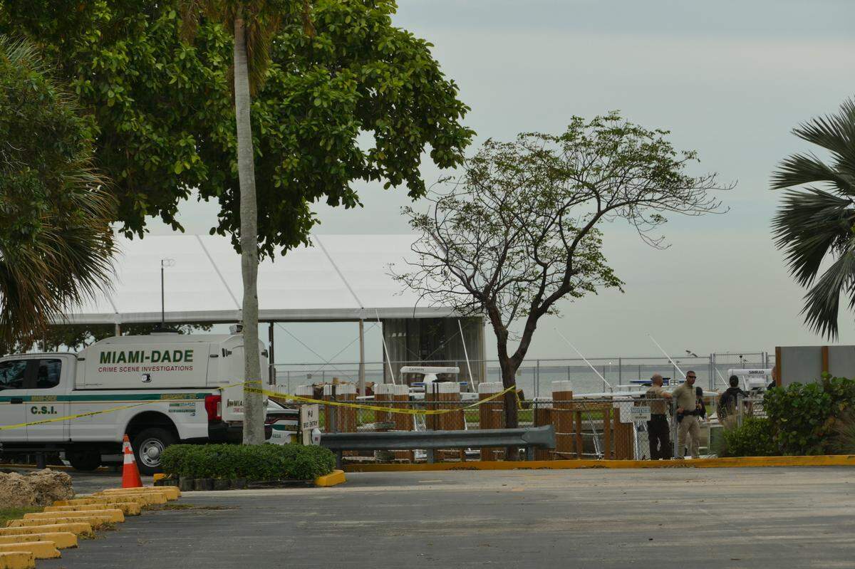 Officers huddle at a pier near the Miami Seaquarium after the body of a woman was found in the area on Friday, Dec. 22, 2023, Miami-Dade police said.