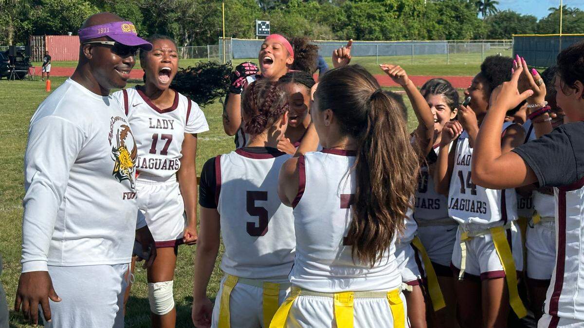 Pembroke Pines Charter flag football coach Keidran Willis (left) celebrates with his team after they beat Homestead 26-6 on Friday in a Class 1A state quarterfinal at the Broncos’ home field.