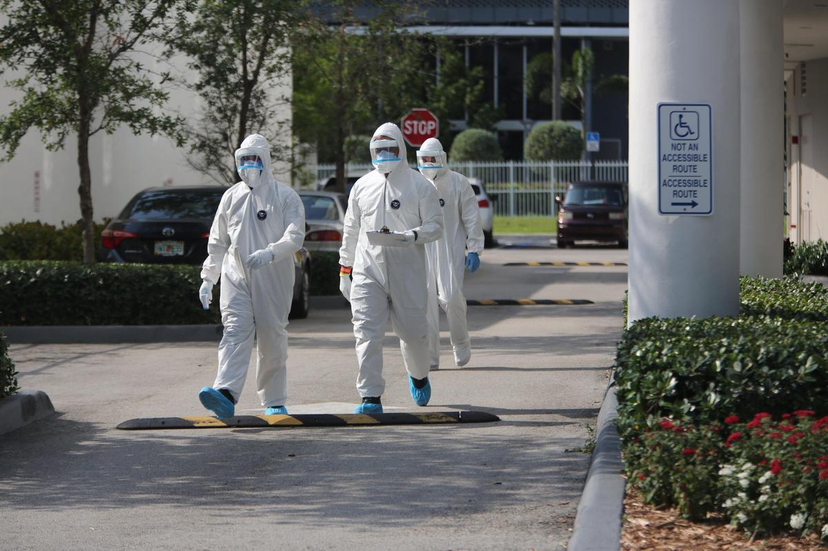 Miami paramedics finish a COVID-19 test for a resident of an apartment building. The city has been conducting testing for qualified homebound residents since March 23, 2020.