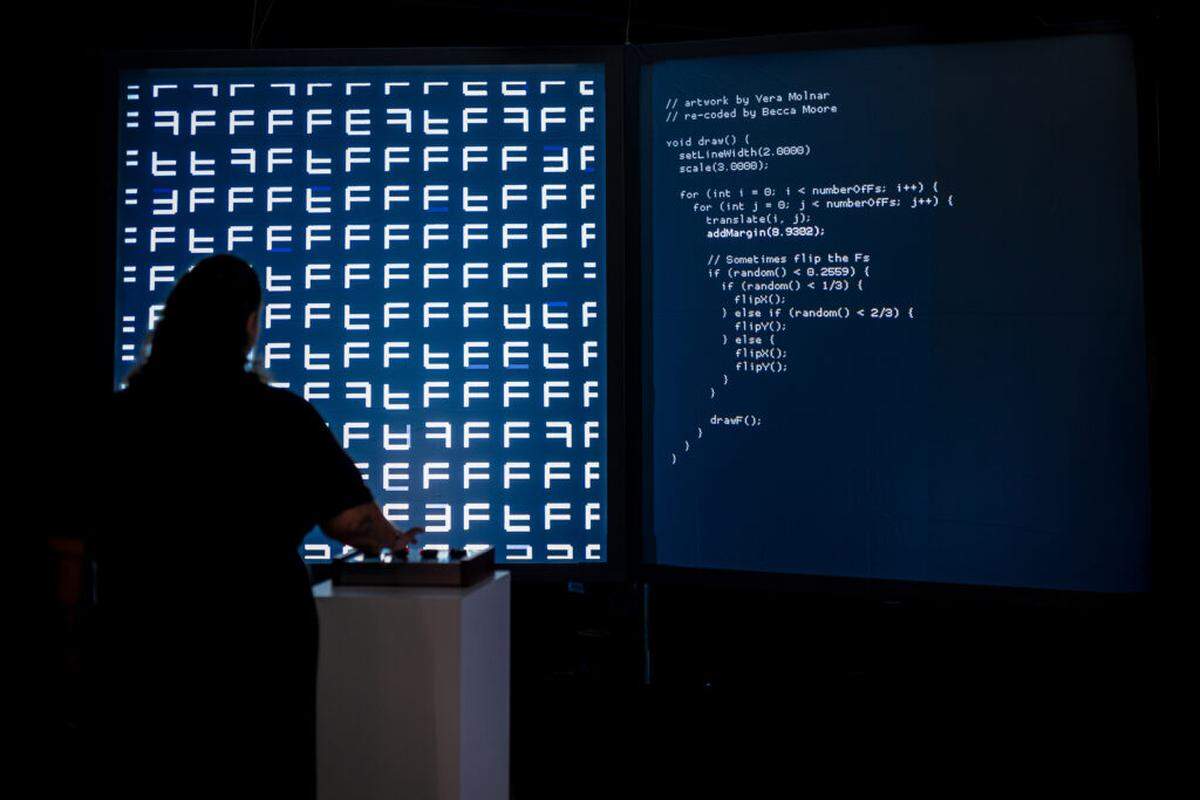 A visitor interacts with the artwork “Re-Coded,” which is an homage to innovators such as Vera Molnar and Muriel Cooper, whose work exists in the space between art and technology.
