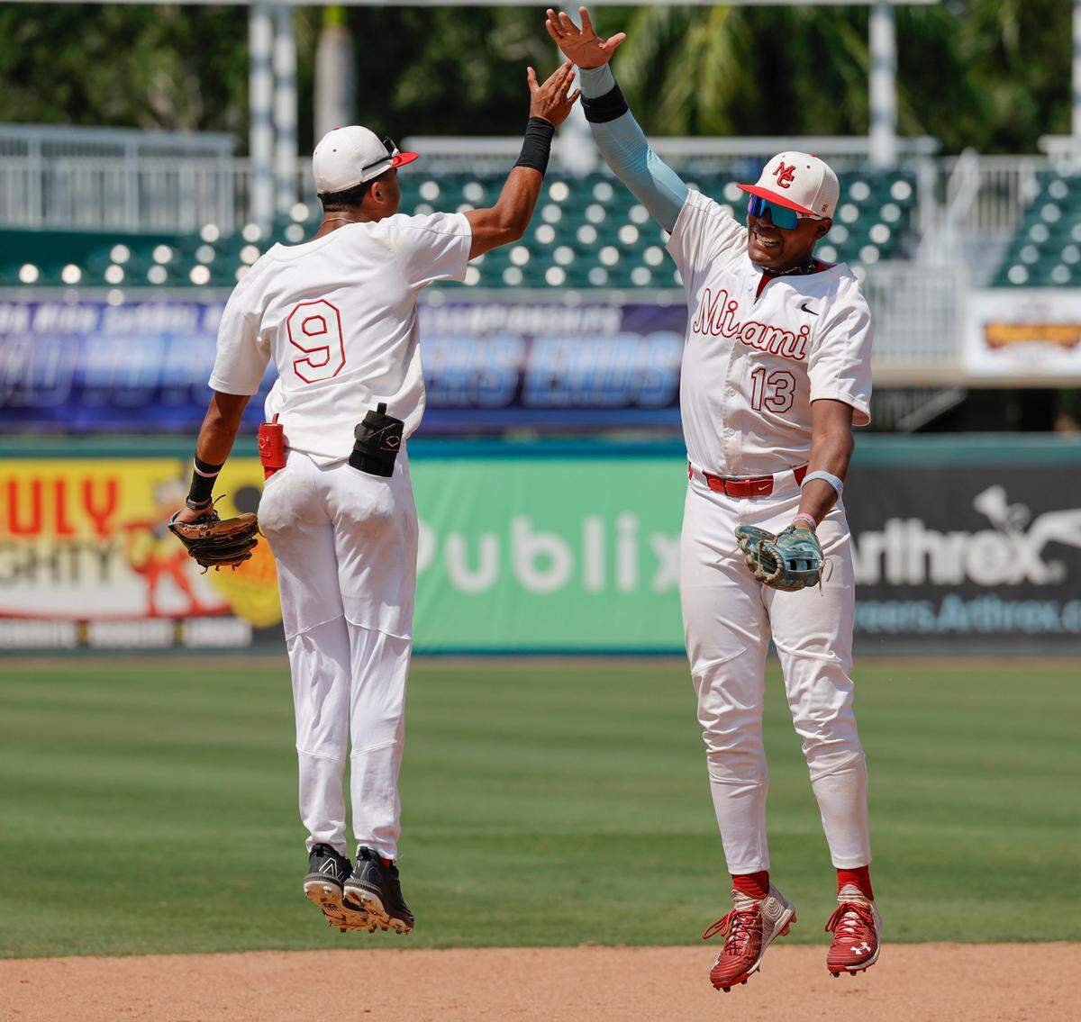 Miami Christian Victors shortstop Ronny Cruz (9) and left fielder Christian De Los Santos (13) celebrate after the team defeats Orlando First Academy Royals baseball in FHSAA Class 2A state baseball semifinal at Hammond Stadium in Fort Myers, Florida on Monday, May 20, 2024.