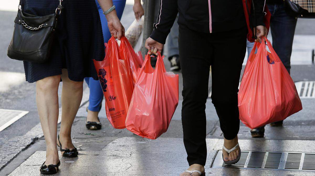 In this Sept. 20, 2016, file photo, women walk with plastic bags through Chinatown in San Francisco. Plastic bag sales are up 120% in areas where bans and fees are enacted, a new study out of the University of Georgia shows.