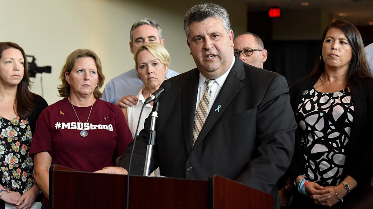 Tony Montalto, whose daughter Gina was a victim of the Marjory Stoneman Douglas High School shootings, is surrounded by parents of other students killed in the Parkland massacre as he speaks during a news conference Thursday.