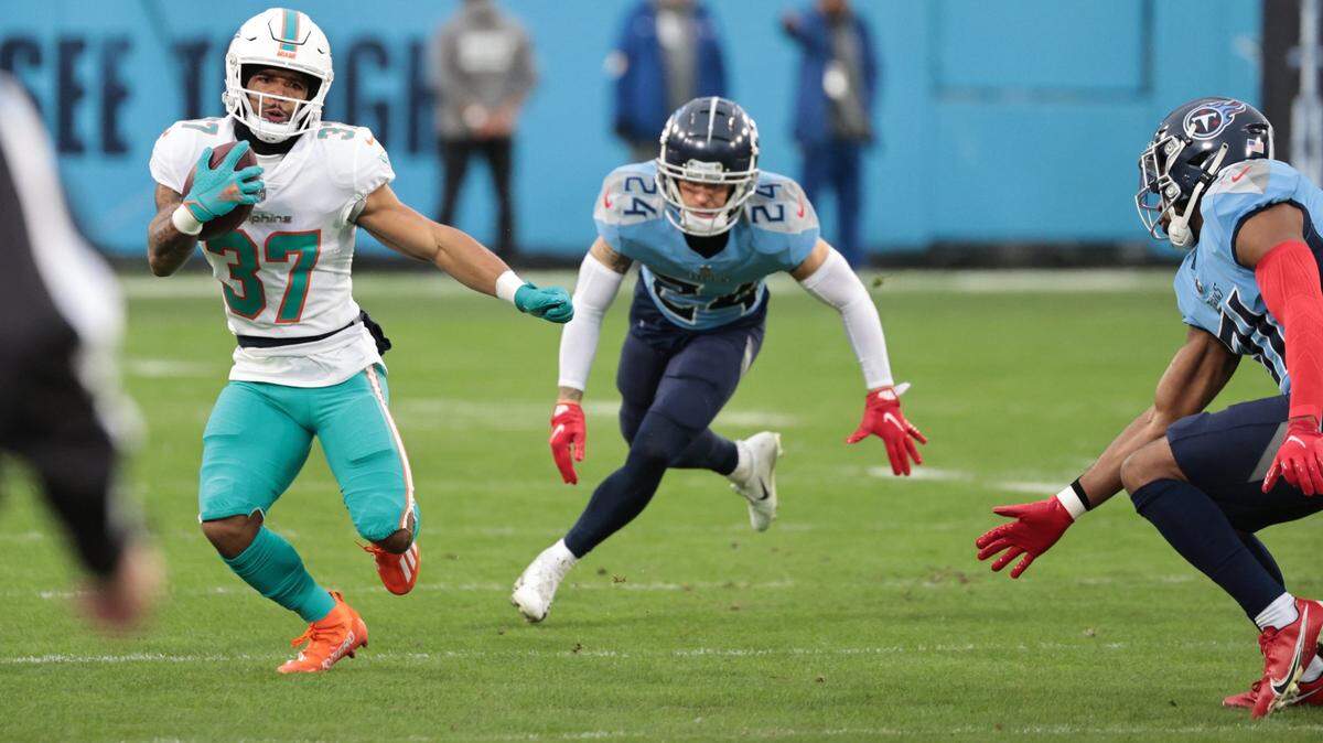 Miami Dolphins running back Myles Gaskin (37) runs for yardage as the Tennessee Titans give chase in the first half at Nissan Stadium in Nashville, Tennessee on Sunday, January 2, 2022.