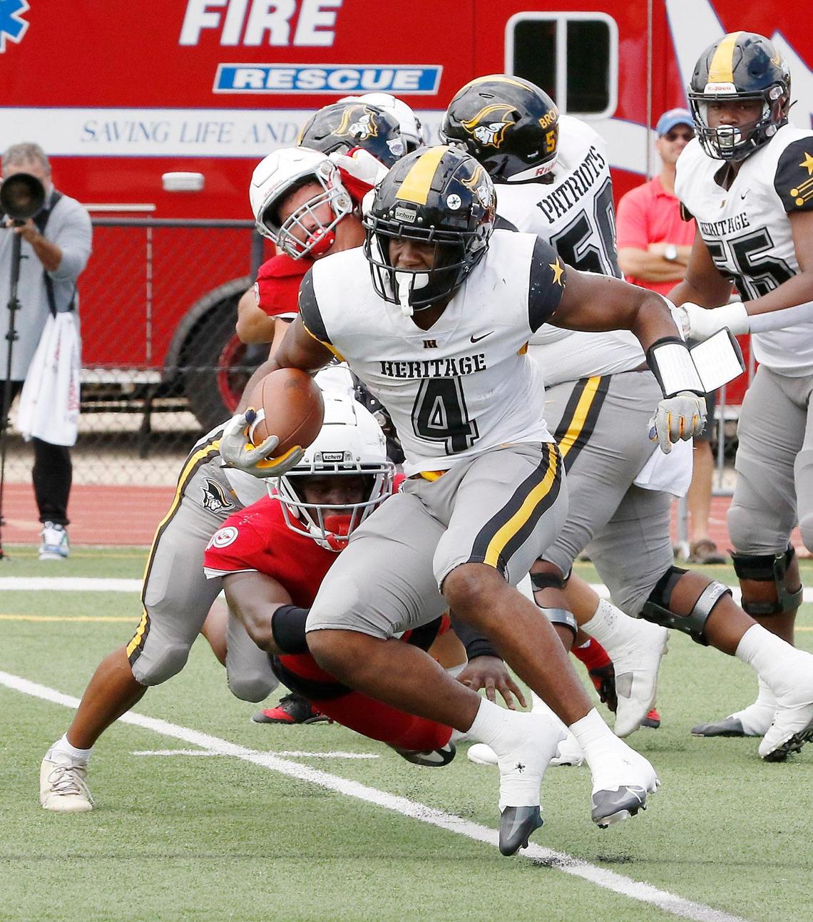 American Heritage Patriots running back Mark Flecher (4) escapes a tackle during football game against Cardinal Gibbons Chiefs on Saturday, October 1, 2022 at Cardinal Gibbons HS in Fort Lauderdale. Andrew Uloza / for Miami Herald