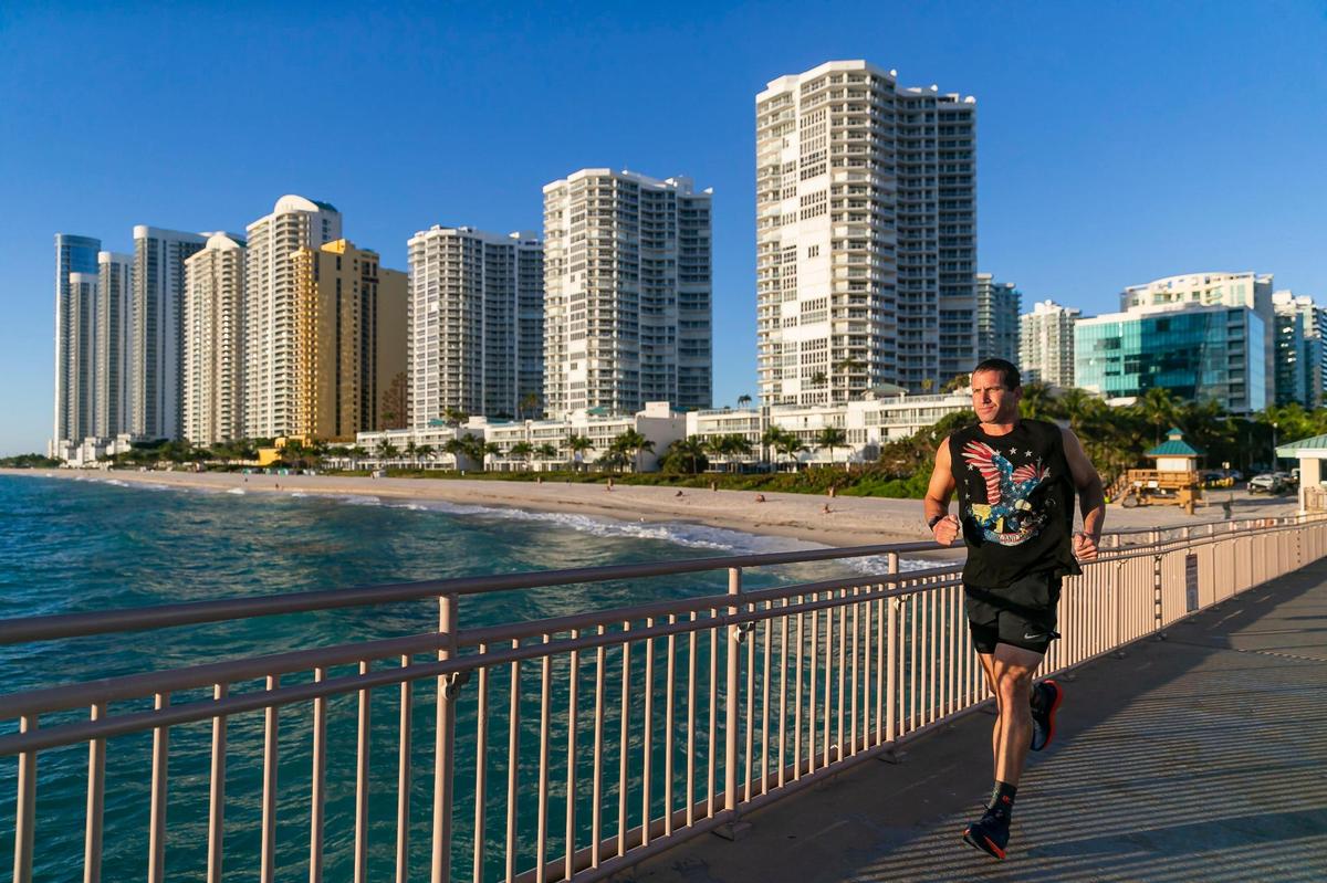 Mika Shevit, 48, who will be running in the half-marathon portion of this year’s Miami Marathon, jogs at the Newport Fishing Pier on Thursday, Jan. 19, 2023 in Sunny Isles Beach, Fla. Shevit has been running a half marathon for more than 650 consecutive days and is looking to reach at least a 1000-day streak.
