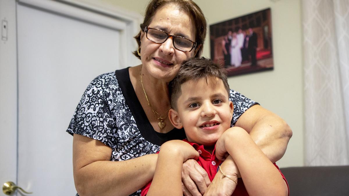 David Anaya, 6, is embraced by his grandmother Maria Alfonso, 63, who cares for him full time, at her home in Miami, on Nov. 19, 2019. David’s mother passed away from a heart attack at age 35, and a few months later, David was diagnosed with a tumor on his optic nerve and autism. David is asking for a laptop so that he may work on his homework from home.