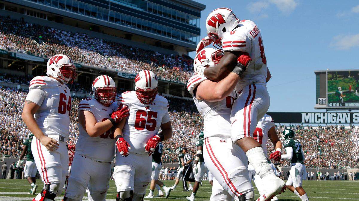 Wisconsin’s Corey Clement, right, celebrates his touchdown against Michigan State with teammates, from left, Brett Connors, Michael Deiter, Olive Sagapolu (65) and Beau Benzschawel during the third quarter of an NCAA college football game, Saturday, Sept. 24, 2016, in East Lansing, Mich. Wisconsin won 30-6. (AP Photo/Al Goldis)