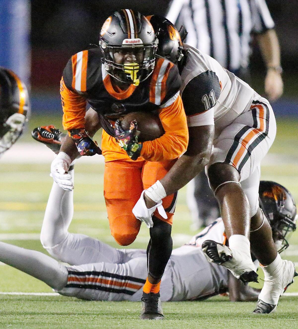 Carol City Chiefs Amare Lee tries to escape a tackle by Booker T. Washington Tornadoes defenders during football game on Friday, September 23, 2022 at Traz Powell Stadium in Miami. Andrew Uloza / for Miami Herald