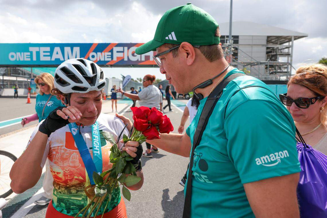 Ediana Albert, 51, who was diagnosed with a sarcoma in her left elbow, cries as she is congratulated by her husband, Cesar Lopez, 47, after finishing the 39-mile bicycle ride during the Dolphins Cancer Challenge XVI event at Hard Rock Stadium on Saturday, Feb. 28, 2026, in Miami Gardens, Florida.